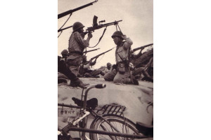 Un soldat japonez folosindu-si tovarsul drept bipod pentru mitraliera sa de Tipul 99, impotriva atacurilor aeriene;